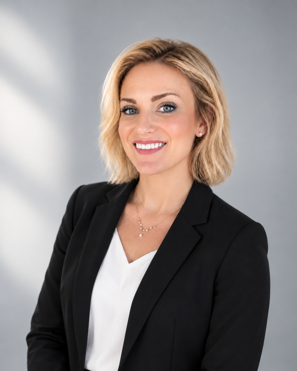 Kyli Lensing, certified sommelier, smiling in a black blazer